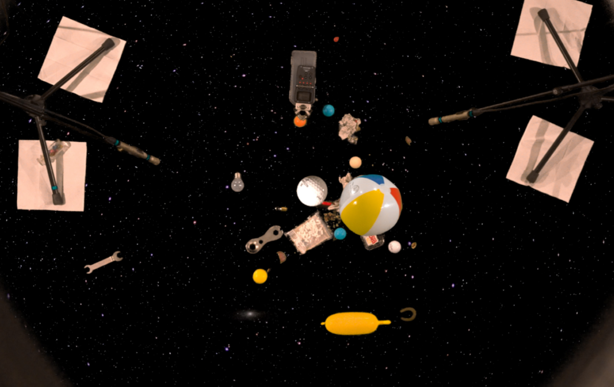 ein Zusammenspiel aus Sternenhimmel, Spielzeug und aufgestellten Mikrofonen bildet ein relativ dunkles Bild mit bunten Farbkleksen ab