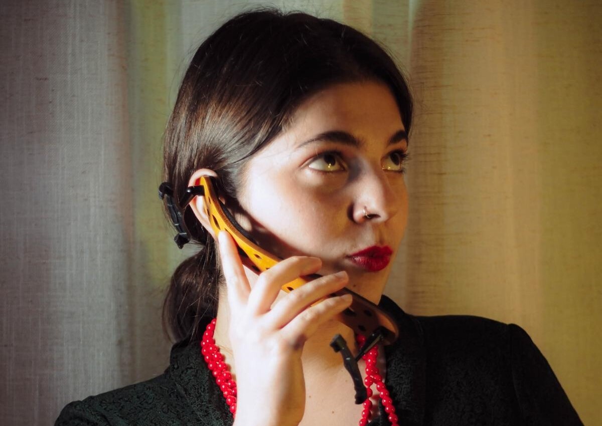 Ioanna Boultadaki hält ihre Schulterstütze der Violine als Telefon an ihr Ohr und macht dabei eine lustige Grimasse.