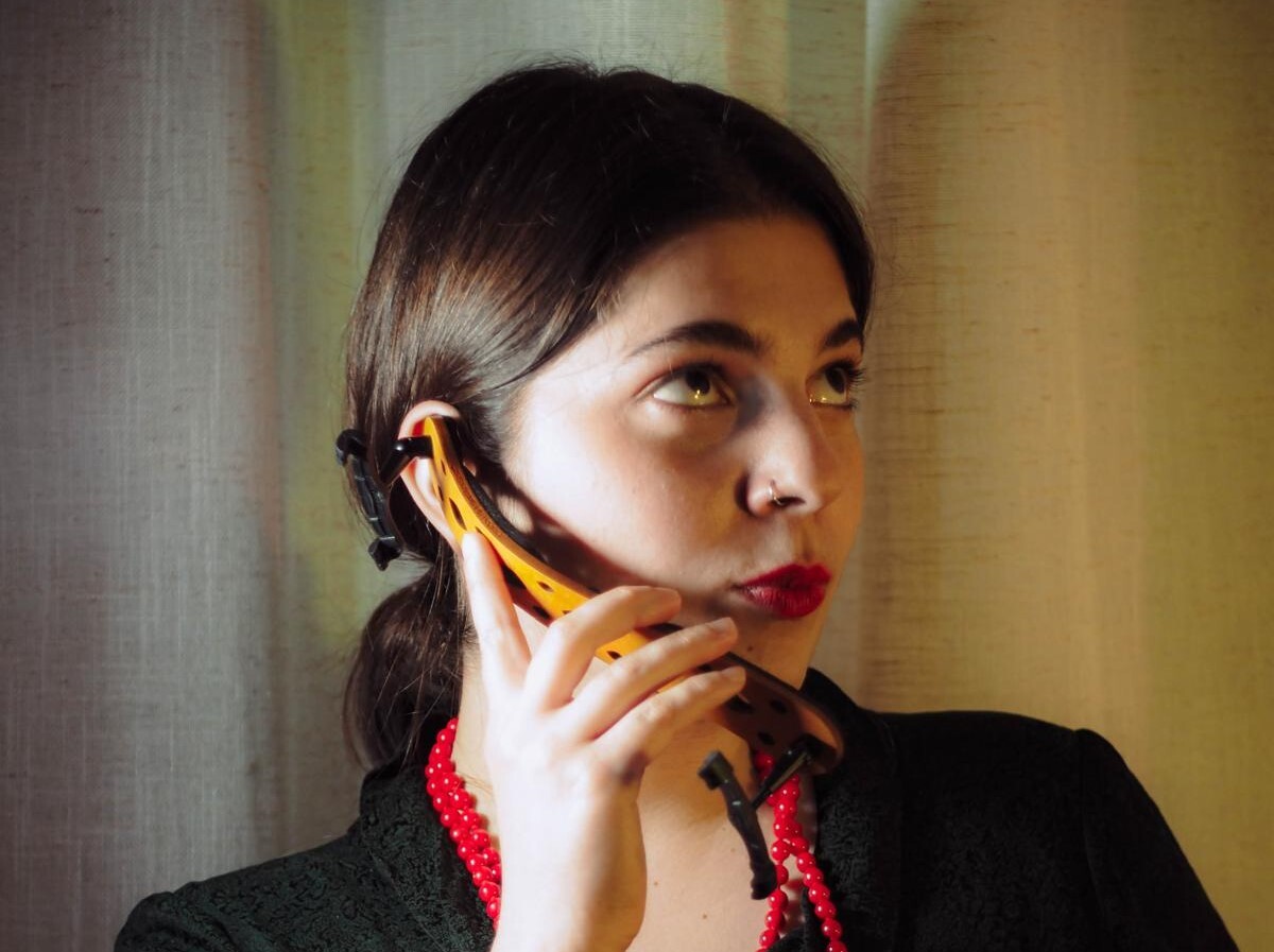 Ioanna Boultadaki hält ihre Schulterstütze der Violine als Telefon an ihr Ohr und macht dabei eine lustige Grimasse.