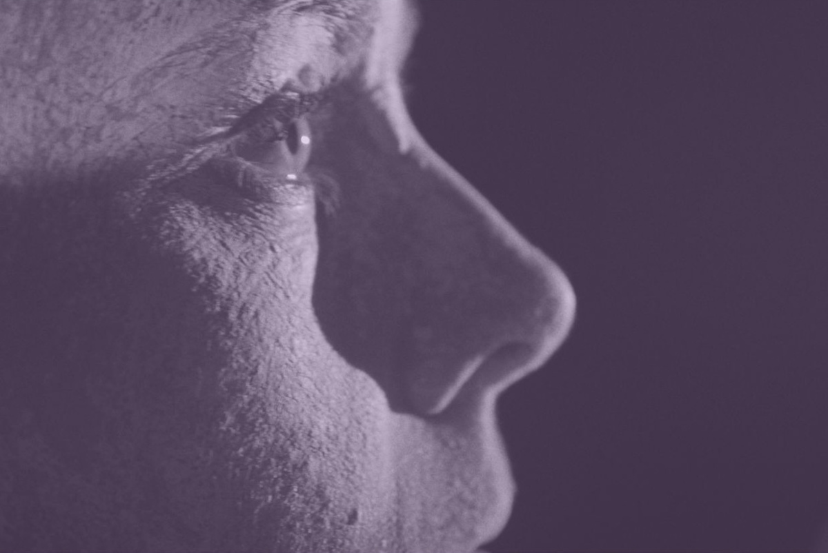 Nahaufnahme eines menschlichen Gesichts im Profil in violettem Licht